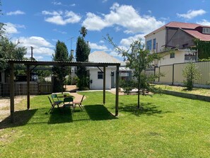 A backyard with a covered patio, a small shed, and a fenced area. - Mill Cottage (Tenterfield)
