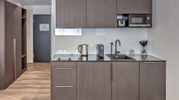 Eine moderne Küche mit integriertem Mikrowellenherd, Wasserkocher und Spüle.