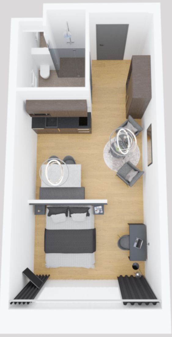 A compact hotel room with a bed, a desk, a chair, a small table, and a wardrobe.