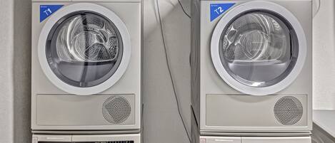 Twee gestapelde voorladers wasmachines met digitale displays en bedieningspanelen.