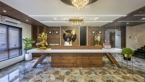 Una reception con un lampadario, orologi e una statua.