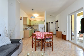 Un espacio habitable compacto con comedor, kitchenette y sofá.