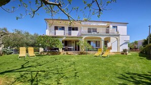 Une maison à deux étages dotée d’un balcon, d’un porche abrité et d’une pelouse bien entretenue.
