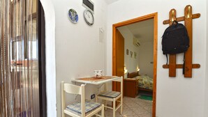 A small room with a table and two chairs, a wooden coat rack, and a door leading to another room. - Apartment 372/851 (Istria - Medulin), 1500m from the beach (Medulin)