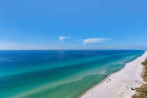 A beach with clear turquoise waters and a sandy shore.