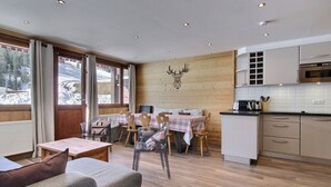 A cozy cabin interior with a dining area, kitchen, and seating space.