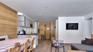 A modern apartment with a kitchen, dining area, and living room.