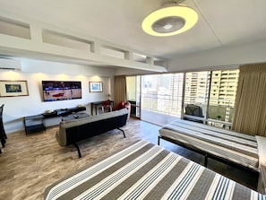 A modern hotel room with a large bed, a sofa, a desk, and a TV. - Entire Condominium - Newly upgraded Waikiki TOP Floor ILIKAI Hotel (Honolulu)