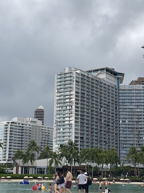 A beachfront hotel with multiple high-rise buildings, palm trees, and a swimming area. - Entire Condominium - Newly upgraded Waikiki TOP Floor ILIKAI Hotel (Honolulu)