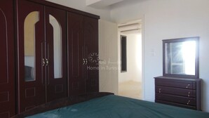 A bedroom with a large wardrobe, a dresser, and a bed. - S+2 close to the sea chott meriem (Sousse)
