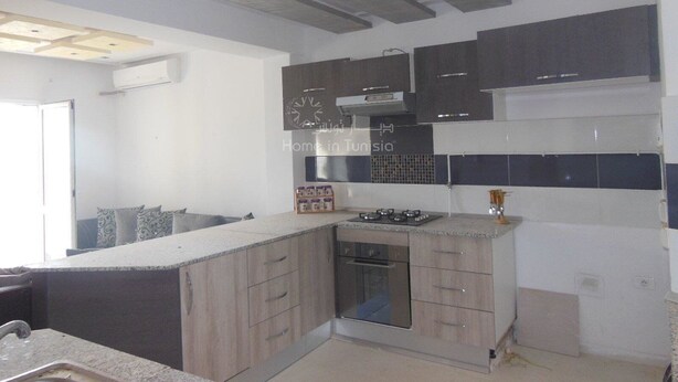 A modern kitchen with grey cabinets, a built-in oven, and a tiled backsplash. - S+2 close to the sea chott meriem (Sousse)