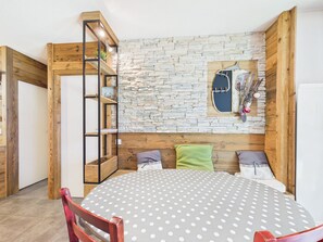 Een gezellige kamer met een ronde tafel, een houten boekenkast en een stenen muur.