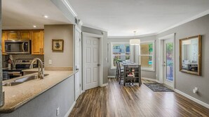 A modern kitchen with a built-in microwave, stainless steel sink, and wooden cabinets.