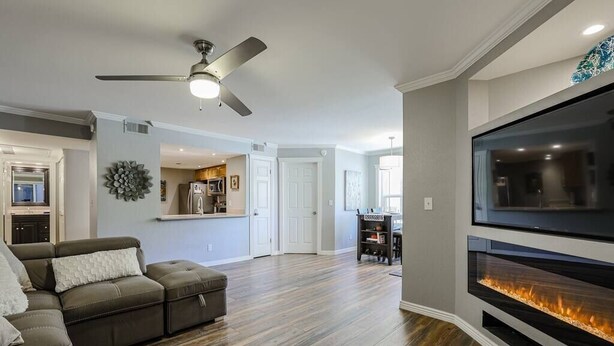 A modern living room with a sectional sofa, a fireplace, and a flat-screen TV.