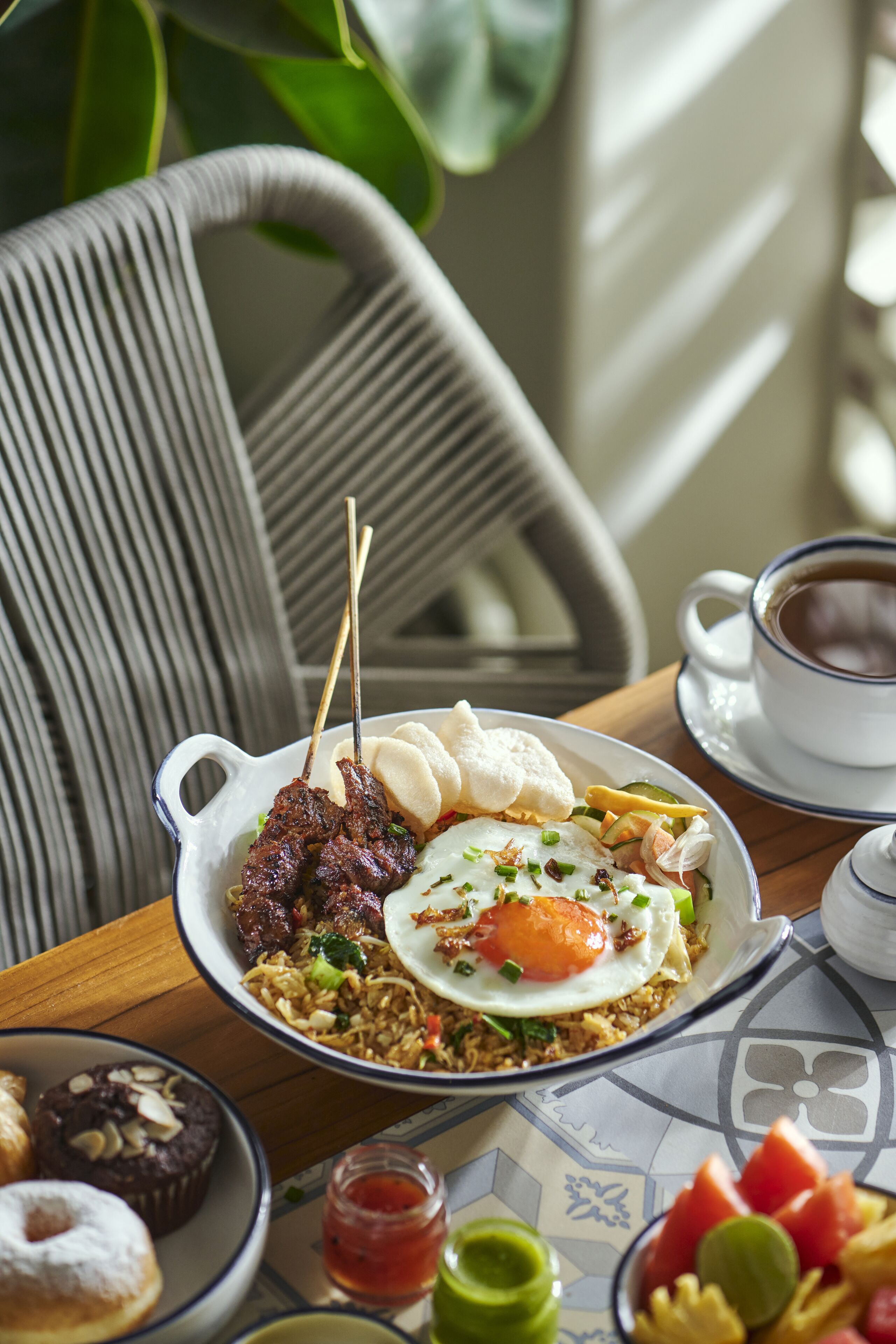 Una mesa de comedor con un plato de comida, una taza de café y una silla.