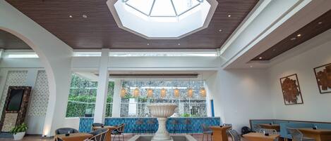 A spacious lobby with a central fountain, seating areas, and a large skylight.