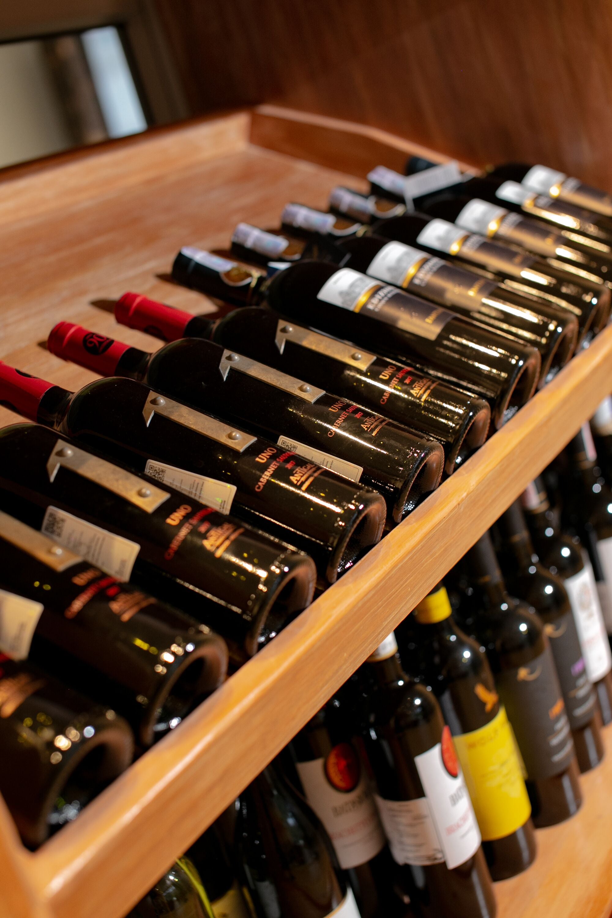 A wooden wine rack holding multiple bottles of wine.
