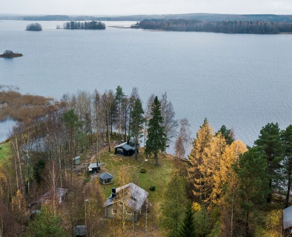 A lakeside property with multiple cabins and a forested area.