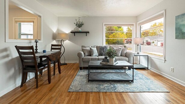 A living room with a sofa, coffee table, and chairs. There is a window providing a view of the outside. - Cute Home in the Heart of Missoula! (Missoula)