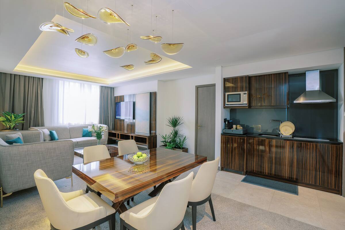 A modern living space with a dining area, kitchen, and seating area.