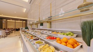A buffet with various fruits and vegetables, a seating area with tables and chairs, and a modern interior design. - Khalidia Palace Hotel Dubai (Dubai)