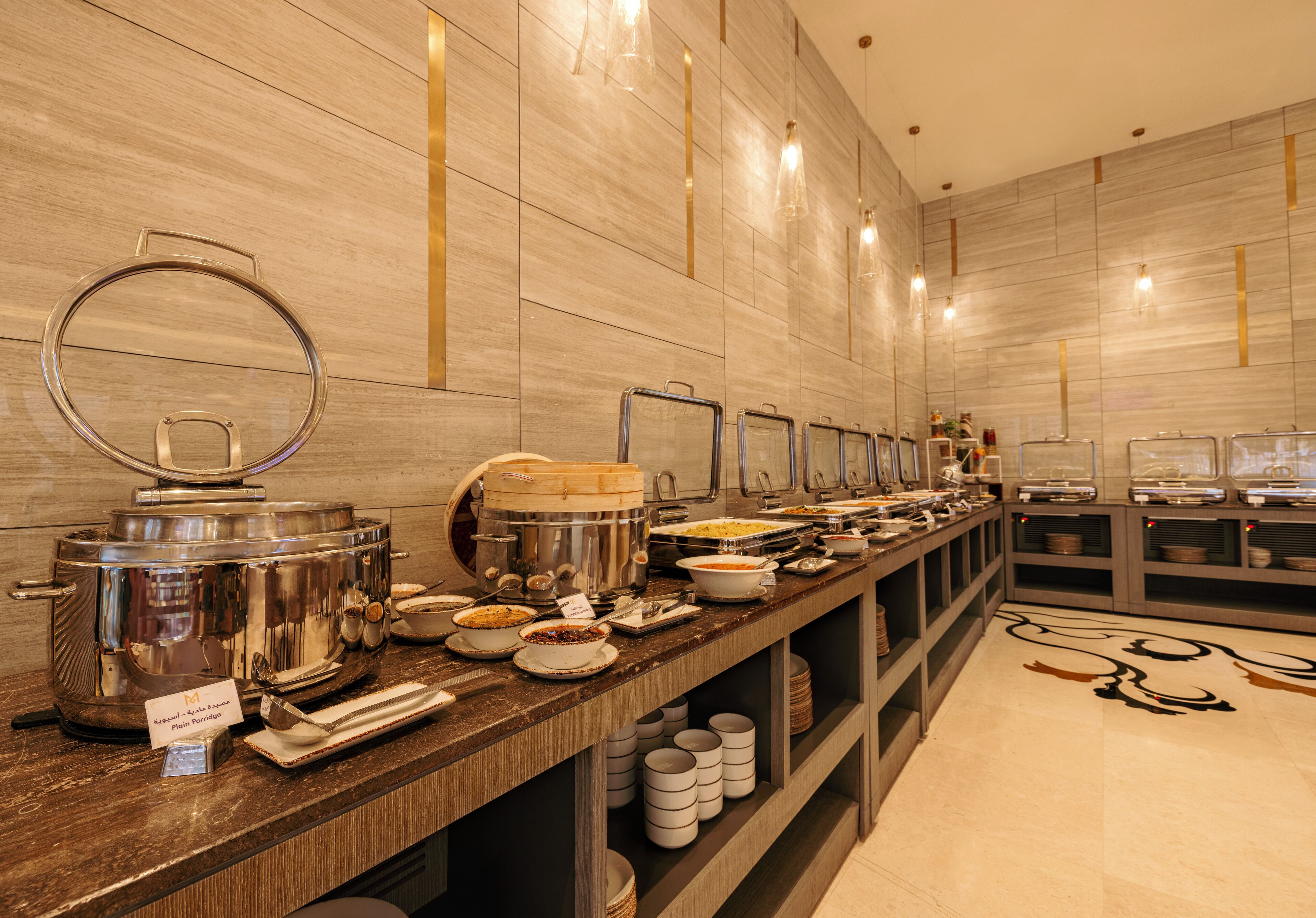 A buffet setup with various food containers and serving utensils.