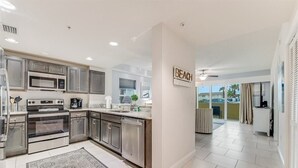 A modern kitchen with stainless steel appliances, a large island, and a view to the outside.