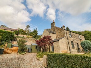 A stone building with a paved driveway and a wooden fence. - 1 Orchard View (Hope Valley)