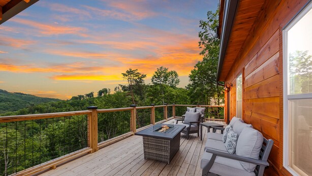 A wooden deck with outdoor furniture, a fire pit, and a view of the landscape. - New Luxury 5 BR Cabin w/ Incredible Views, Hot Tub, Wi-Fi, Arcade, Pool Table (Sevierville)