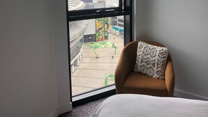 A hotel room with a large window offering a view of a cityscape and a river. - Harbour views at Docklands, Melbourne. Next to Marvel stadium (Docklands)