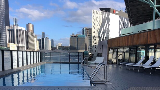 A rooftop pool with a cityscape view, including modern buildings and a clear sky. - Harbour views at Docklands, Melbourne. Next to Marvel stadium (Docklands)