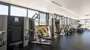 A modern gym with various exercise machines, large windows, and a clean, spacious layout. - Harbour views at Docklands, Melbourne. Next to Marvel stadium (Docklands)