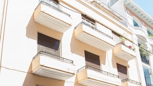 A multi-story building with balconies, a door, and a parked scooter. - Chic Charming Central Athens Apt. (Athens)