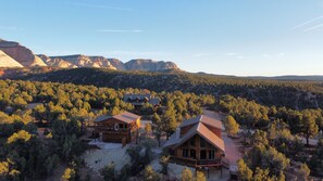 Escape to a rustic mountain retreat with a spacious deck and breathtaking views of the surrounding forest and rugged peaks.