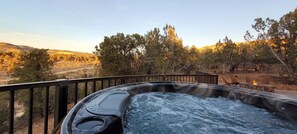 Relax in the hot tub on the outdoor deck, surrounded by serene natural views.