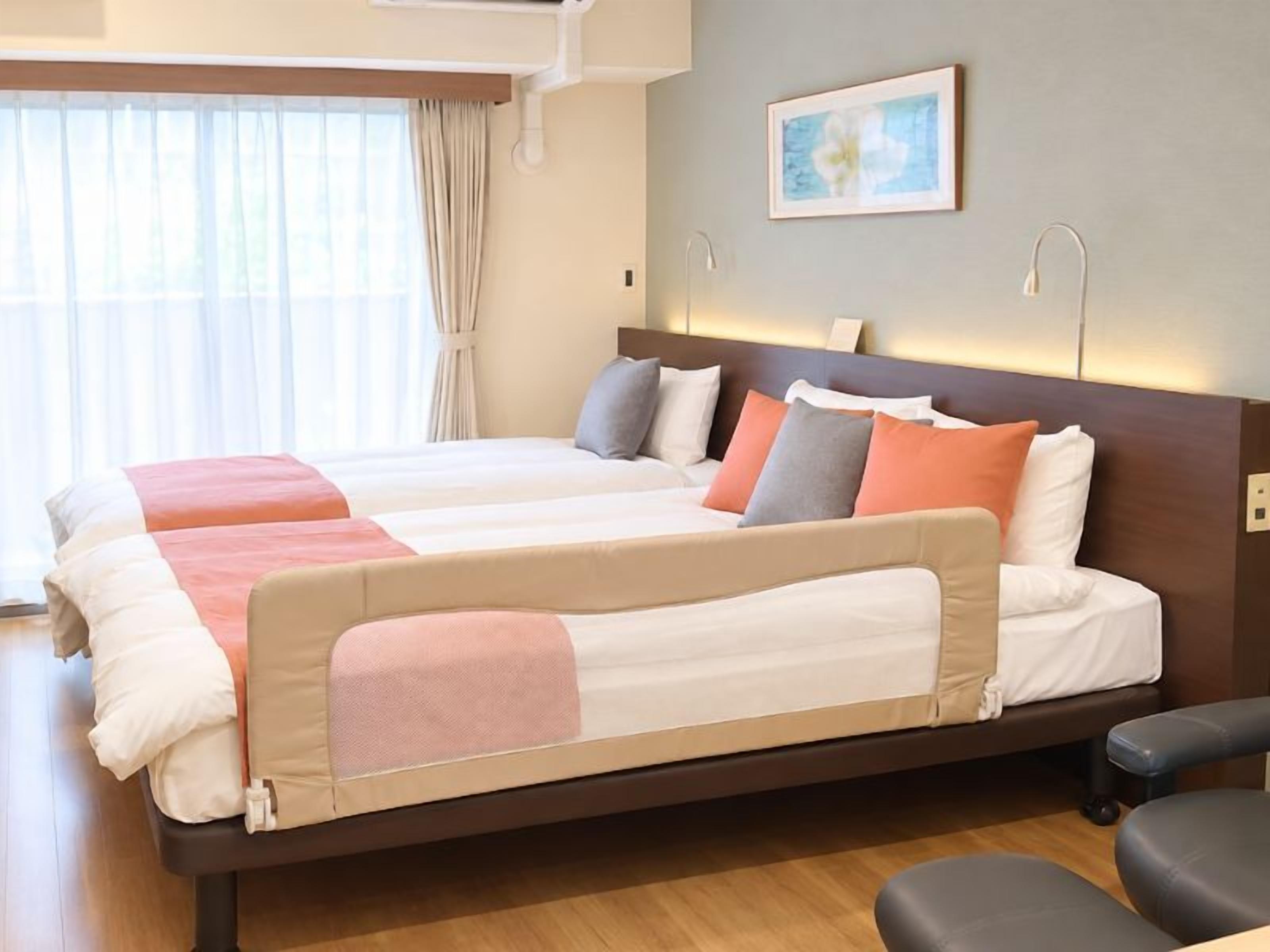 Una cama doble con estructura de madera, dos mesitas de noche y cabecero con iluminación integrada.