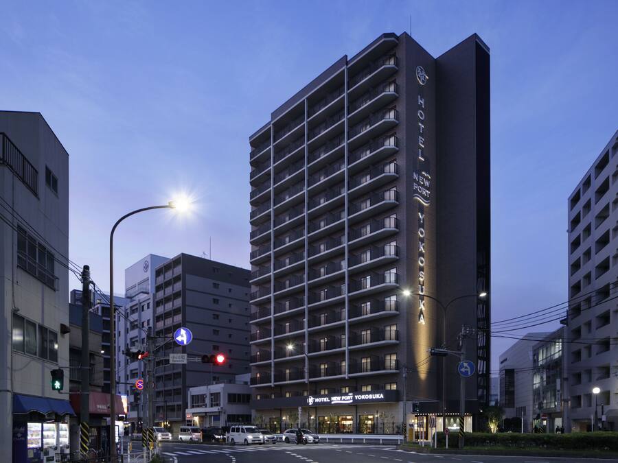 A multi-story hotel with a modern design, featuring balconies and a prominent sign.
