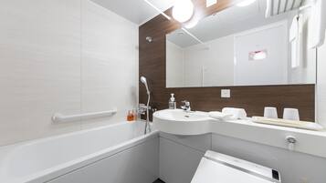 A modern bathroom with a bathtub, a sink, a mirror, and a towel rack.