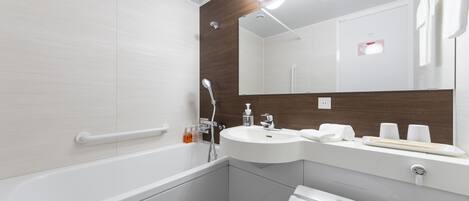 Un baño moderno con bañera, lavamanos, espejo y toallero.