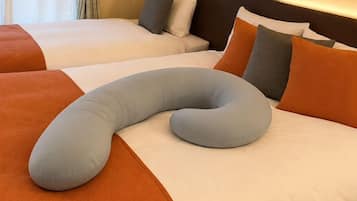 A hotel room with two beds, each with white bedding and orange accents.