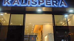 A building facade with a decorative geometric pattern and a sign reading "KALISPERA".