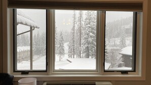 A room with a large window overlooking a snowy landscape.