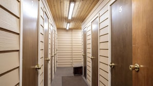 A hallway with lockers numbered 2 to 5, wooden walls, and a carpeted floor.