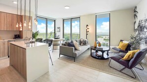A modern apartment with a kitchen, dining area, and living room. It features large windows, a view of the city, and a mix of contemporary furniture.