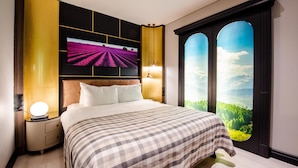 Un dormitorio con una cama grande, un televisor montado en la pared y una ventana con vistas panorámicas.