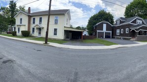 A residential street with houses, a stop sign, and a clear sky. - 1st Class Rentals Munson Manor VIII at 1 Columbia Street a 1 Bedroom Apartment (Oneonta)