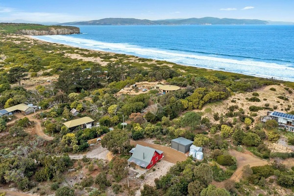 Experience the charm of this two-storey red cottage with its picturesque setting just a short stroll from the beach.
