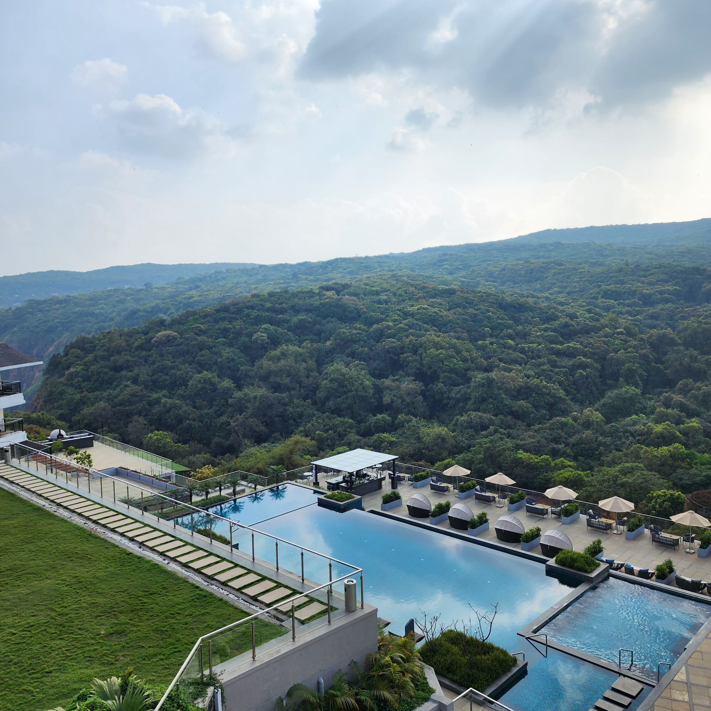 Ein Pool auf dem Dach mit Blick auf einen bewaldeten Hang.