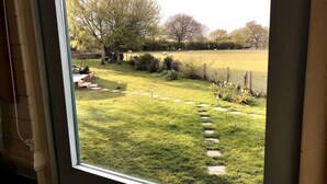 A view of a grassy yard with stepping stones leading to a brick structure. - Meadowsweet - luxury Shepherd's Hut, amazing views (Herstmonceux)