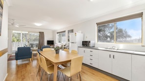 Una cocina moderna con comedor, ventanas amplias y vistas al exterior.
